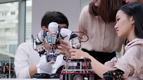 Group-of-electronics-engineer-try-to-fix-robot-at-lab.-Technology-and-innovation-concept.