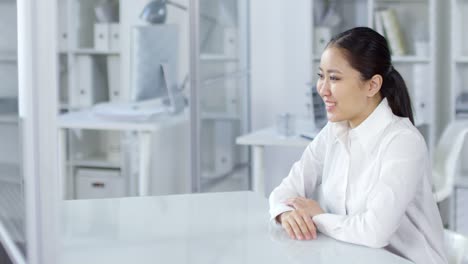 Asiatische-Frau-mit-Video-Anruf-auf-unsichtbaren-AR-Touchscreen-im-Büro