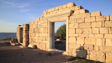 Couple-in-love-photographed-and-kissing-on-ruins-of-Chersonesus-basilica,-ancient-Greek-town-near-modern-Sevastopol.-Two-lovebirds-in-autumn-sunset.-UNESCO-World-Heritage-Site.-Crimea,-Russia.