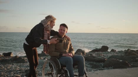 Male-wheelchair-user-and-his-female-friend-are-taking-selfie-by-smartphone