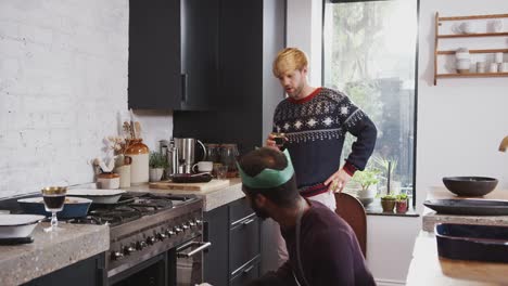 Homosexuell-männliche-paar-zu-Hause-in-der-Küche-Kochen-Abendessen-am-Weihnachtstag-nehmen-Huhn-aus-dem-Ofen