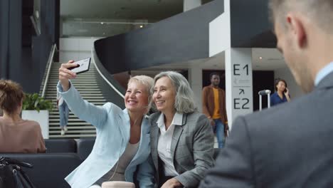 Zwei-Frauen-mittleren-Alters-machen-Selfie-am-Flughafen