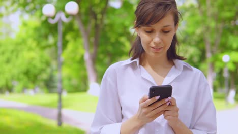 retrato-millennials-chica-chateando-en-línea-uso-celular-en-el-parque