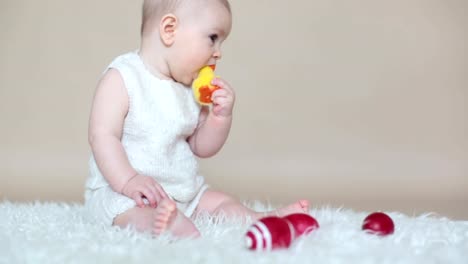 Cute-little-toddler-baby-boy,-playing-with-colorful-easter-eggs-and-little-decorative-ducks,-isolated-shot,-beige-background