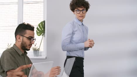 Female-Teacher-Assisting-Students-with-Tasks-in-Futuristic-College-Classroom