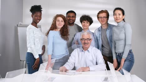 Senior-Professor-posiert-mit-Studenten-im-futuristischen-Klassenzimmer