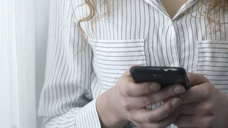 Junge-Frau-SMS-mit-ihrem-Smartphone