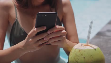 woman-chatting-by-smartphone-in-pool,-closeup