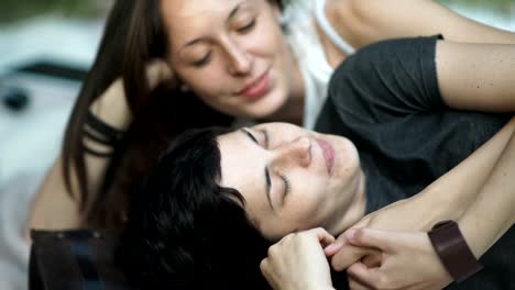 Lesbians-laying-on-cover-make-heart-with-fingers