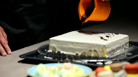 The-young-man-pours-chocolate-cake.-A-man-prepares-a-cake-for-the-modern-kitchen