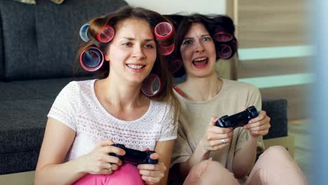 Cámara-lenta-de-dos-mujeres-divertidas-jugar-juegos-de-consola-con-gamepad-y-divertirse-en-casa