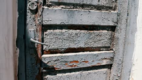 Old-vintage-wooden-shabby-with-gray-paint-a-front-door-on-the-street