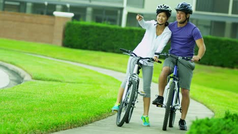 Asian-Chinese-male-female-couple-cycling-outdoors-together