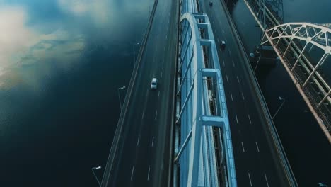 Cars-and-train-moves-on-a-bridge-over-a-frozen-river-aerial-drone-footage