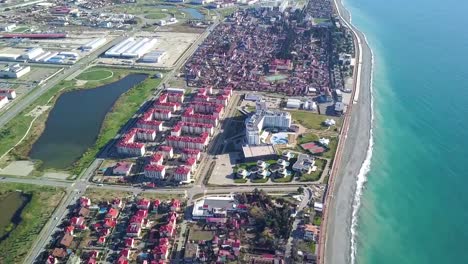 Parte-de-la-ciudad-de-moderno-complejo-junto-al-mar-en-un-día-soleado.-Clip.-Vista-superior-de-la-ciudad-cerca-del-mar