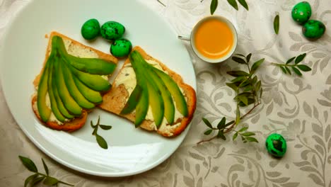 Breakfast-consisting-of-espresso,-an-avocado-sandwich-and-green-Easter-eggs