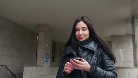 Mujer-hermosa-de-raza-mixta-con-aplicación-de-tecnología-de-teléfono-inteligente-caminando-por-las-calles-urbanas-feliz