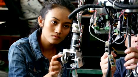 Female-engineer-testing-his-robot-in-workshop.-4k-resolution.