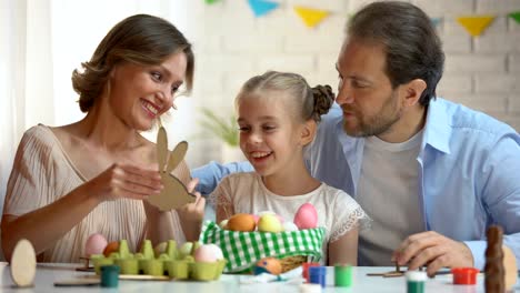 Familie-hölzernes-Spielzeug-in-Form-von-Hasen,-Ostern-Symbol,-handgemachte-Dekoration-bewundern