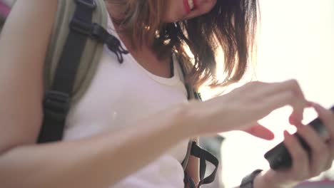 Cheerful-Asian-backpacker-blogger-woman-using-smartphone-for-direction-and-looking-on-location-map-while-traveling-at-Chinatown-in-Beijing,-China.-Lifestyle-backpack-tourist-travel-holiday-concept.