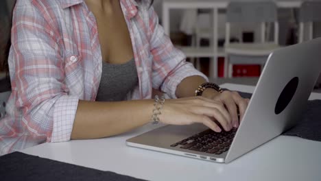 Lächelnde-junge-Frau-mit-langen-Haaren,-die-Eingabe-auf-Laptop-zu-Hause.