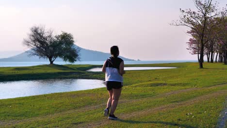 Eine-fette-asiatische-Frau,-die-abends-im-natürlichen-Sonnenlicht-joggt.
Sie-versucht,-mit-Übung-Gewicht-zu-verlieren.--Konzept-Gesundheit-mit-Bewegung.-Zeitlupe