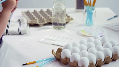 Little-girl-painting-craft-Easter-eggs-with-acrylic-paint.