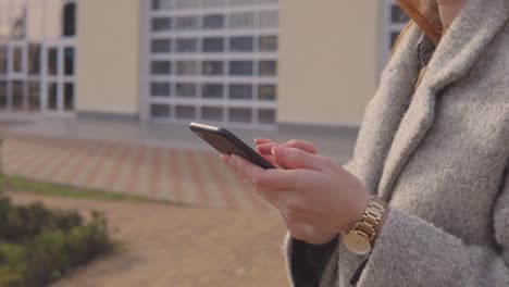 Woman-in-overcoat-holding-smartphone