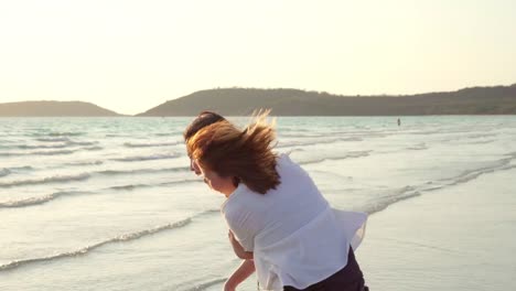 Junges-asiatisches-lesbisches-Paar-läuft-am-Strand.-Schöne-Freundinnen-freuen-sich,-sich-bei-Sonnenuntergang-am-Abend-am-Strand-am-Meer-zu-vergnügen.-Lifestyle-lesbisches-Ehepaar-reist-nach-Strandkonzept