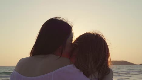 Young-Asian-lesbian-couple-kissing-near-beach.-Beautiful-women-lgbt-couple-happy-relax-enjoy-love-and-romantic-moment-when-sunset-in-evening.-Lifestyle-lesbian-couple-travel-on-beach-concept.