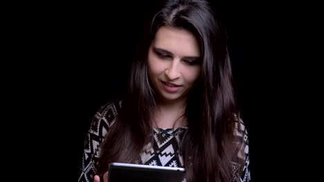 Closeup-shoot-of-young-attractive-caucasian-female-using-the-tablet-talking-smiling-and-looking-at-camera-with-background-isolated-on-black