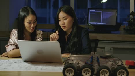 Woman-Electronics-Engineers-Examining-Project-At-Office.-Two-Asian-Female-Compare-Data-On-a-Personal-Computer.-People-with-technology-or-innovation-concept.