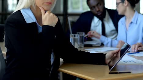 Businesswoman-pondering-project-holding-tablet,-online-app-for-strategy-planning