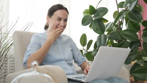 Aufgeregte-Frau-mit-Laptop-zu-Hause