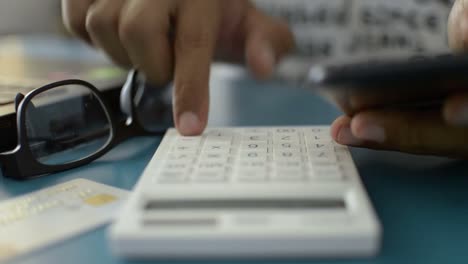 Hands-of-a-man-calculating-expenses-from-credit-card.