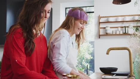 Pareja-gay-mujer-en-casa-en-la-cocina-lavando-y-bebiendo-vino-después-de-la-cena-el-día-de-Navidad