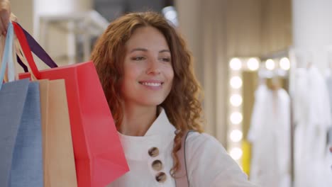 Feliz-cliente-femenino-haciendo-selfie-con-bolsas-de-compras