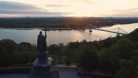 Aerial-view-monument-Prince-Vladimir-with-cross-on-evening-Kiev-city-landscape