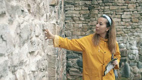 Female-tourist-is-touching-an-ancient-brick-wall