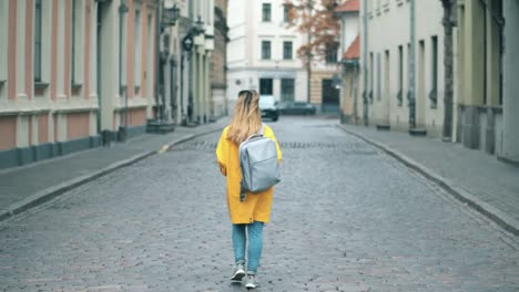 A-woman-walks-along-the-a-street-in-historical-part-of-a-city.