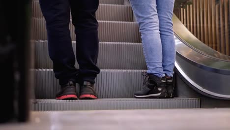 Piernas-de-personas-moviéndose-en-un-ascensor-de-escaleras-mecánicas-en-el-centro-comercial.-Pies-de-comprador-en-Escalera-Saltadora-en-el-Centro-Comercial