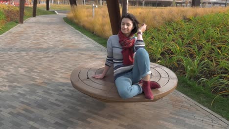 Caucasian-woman-riding-a-little-carousel-in-a-park-time-lapse