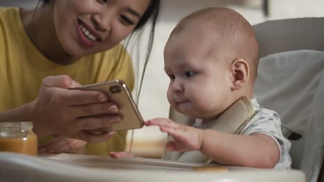 Mutter-zeigt-Smartphone-zu-Baby