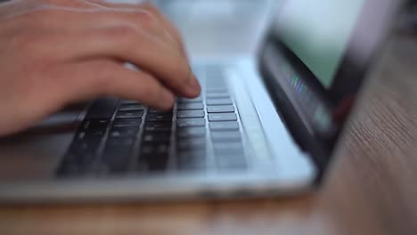 Close-up-of-male-hands-typing-on-laptop-keyboard,-moving-camera