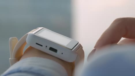 Woman-using-wearable-white-smart-watch-in-office---close-up-side-view