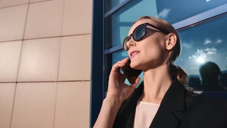 Smiling-face-of-joyful-businesswoman-discussing-work-use-telephone-outdoor.-4k-Dragon-RED-camera