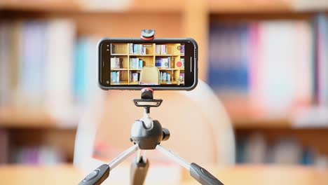 A-mobile-phone-mounted-on-a-tripod-is-used-to-teach-students-online-at-the-library.