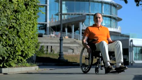 Pleasant-senior-man-sitting-in-the-wheelchair-outdoors