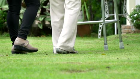 Elderly-woman-exercise-walking-in-backyard-with-daughter