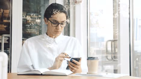 Businesswoman-using-phone-at-cafe